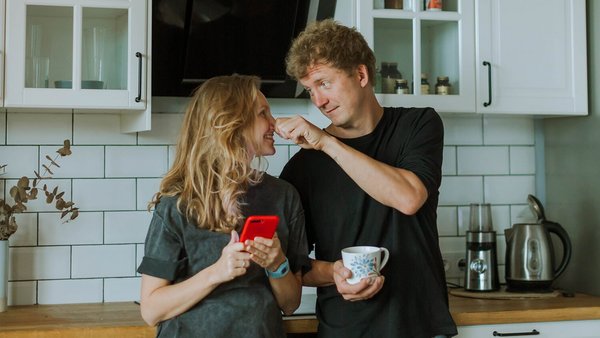 Γυναίκα και άντρας στέκονται στην κουζίνα γελώντας – κοινός λογαριασμός 