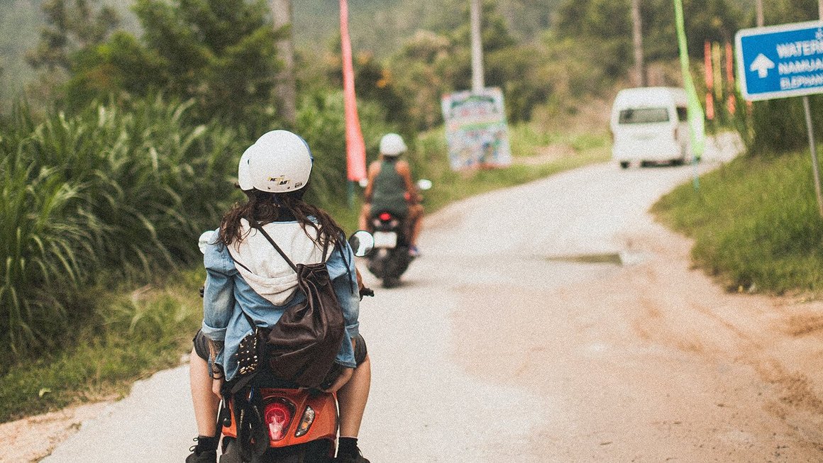 Νεαρή γυναίκα σε μηχανάκι - backpacking στο εξωτερικό