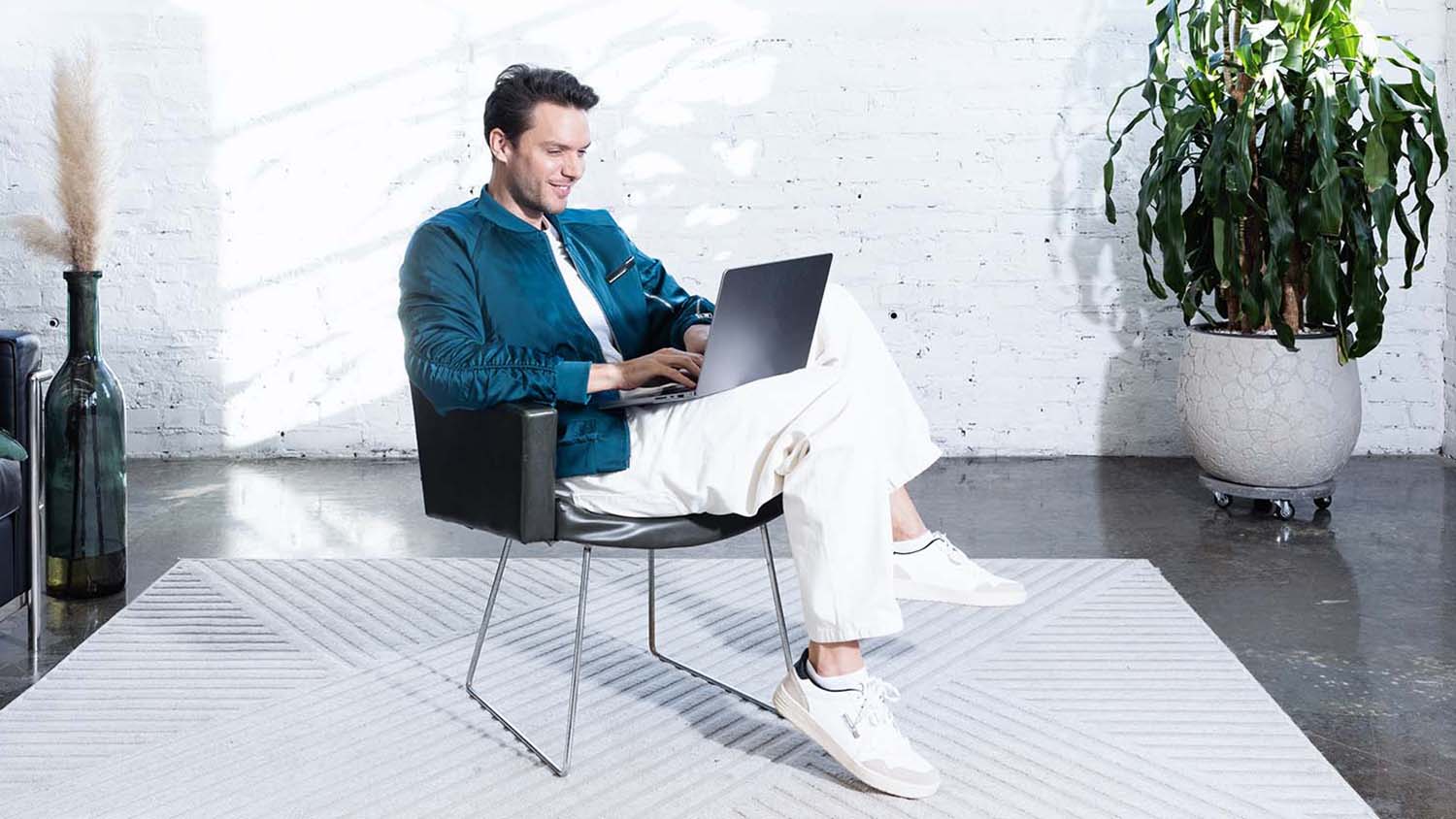 Νεαρός δουλεύει στον φορητό υπολογιστή και σχεδιάζει τον προϋπολογισμό του.