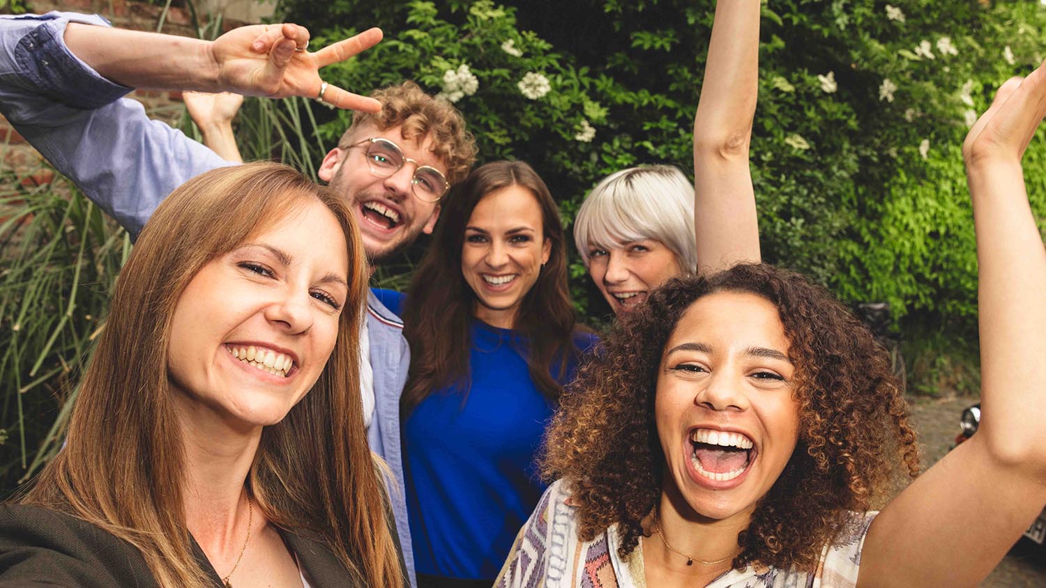 Σχεδιάζοντας διακοπές με φίλους – πώς λειτουργεί Πέντε φίλοι στέκονται κοντά και γελούν στην κάμερα