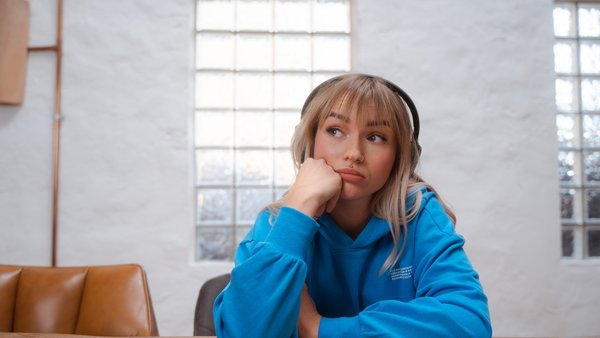 Η νεαρή γυναίκα κοιτάζει σκεπτόμενη στο πλάι.